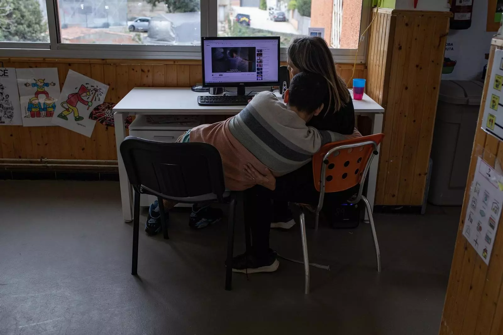 Una educadora atenent un noi amb discapacitat intel·lectual a l'associació Aspassim de Barcelona.